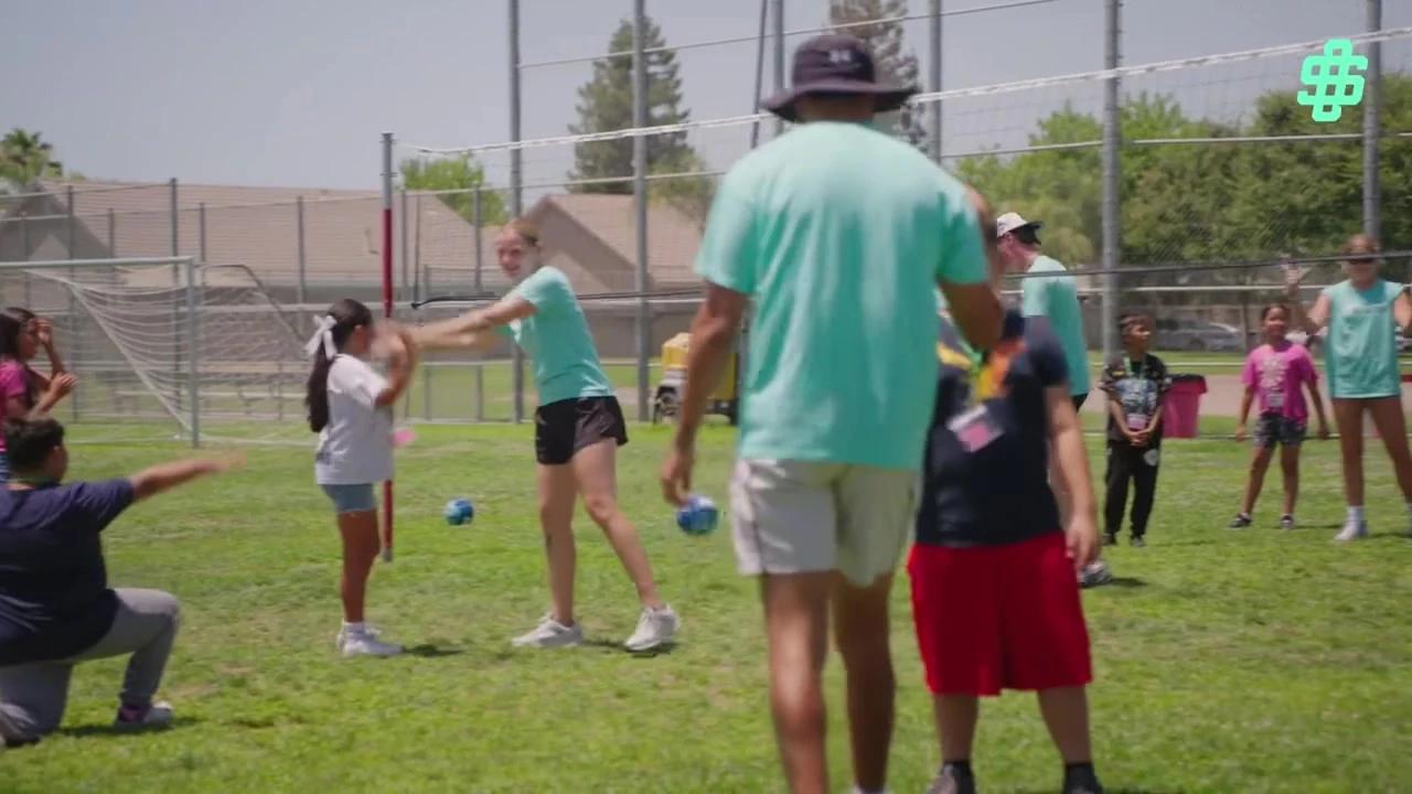 Offseason mentors and students taking part in a volleyball activity on the field